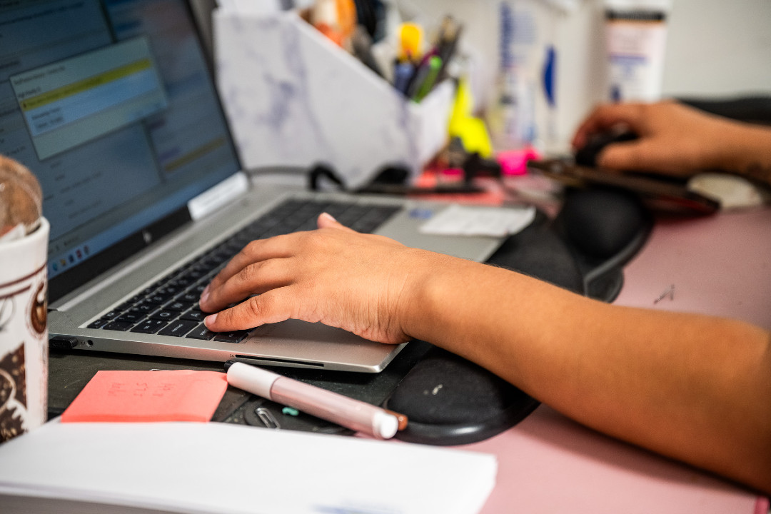 a hand hovering over a laptop