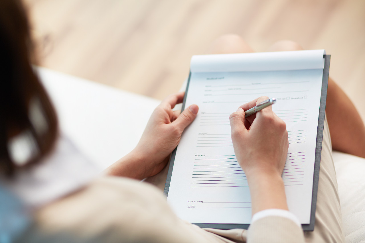 a woman signing an official looking document